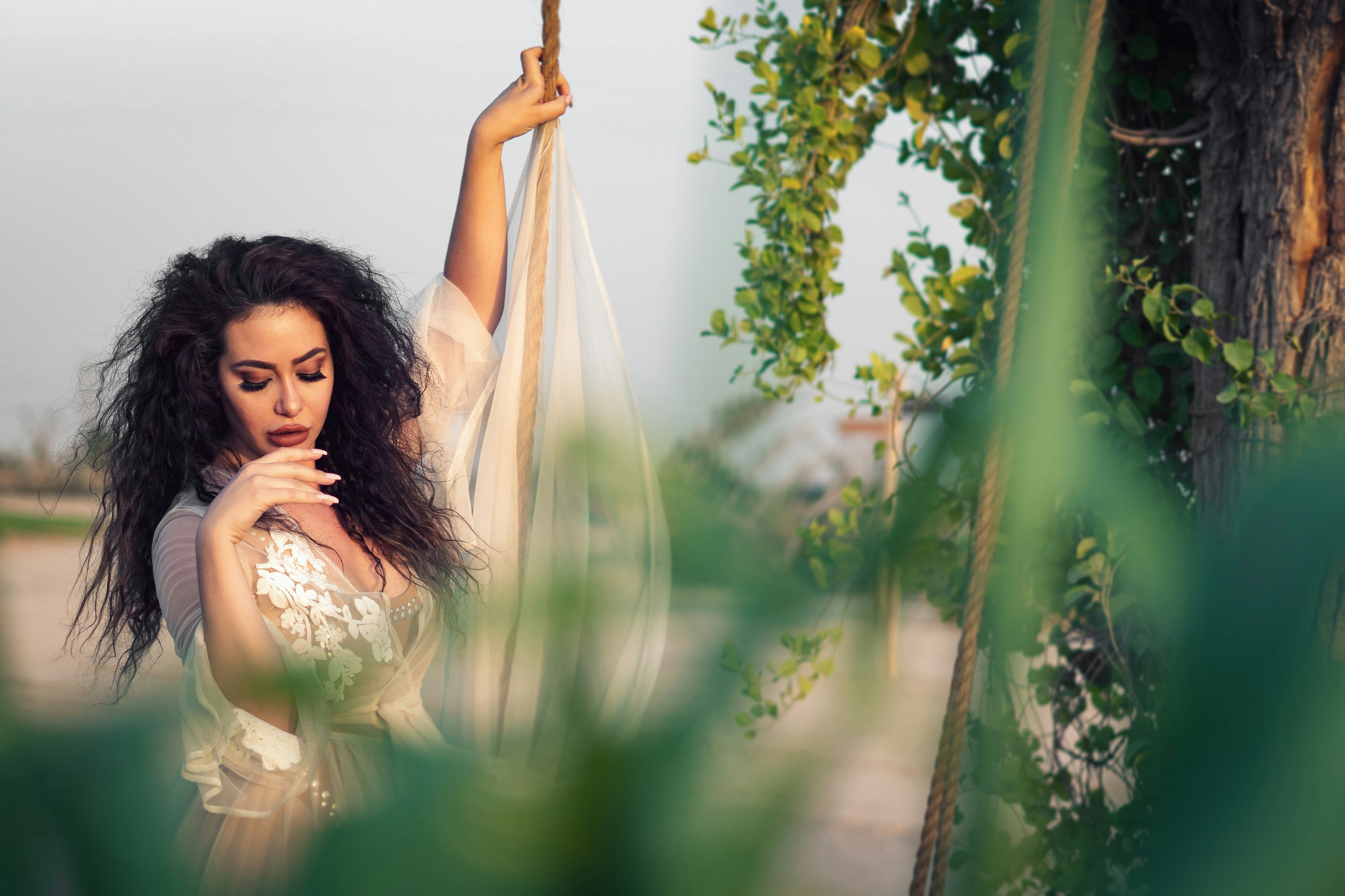 woman in white dress holding on brown rope during daytime